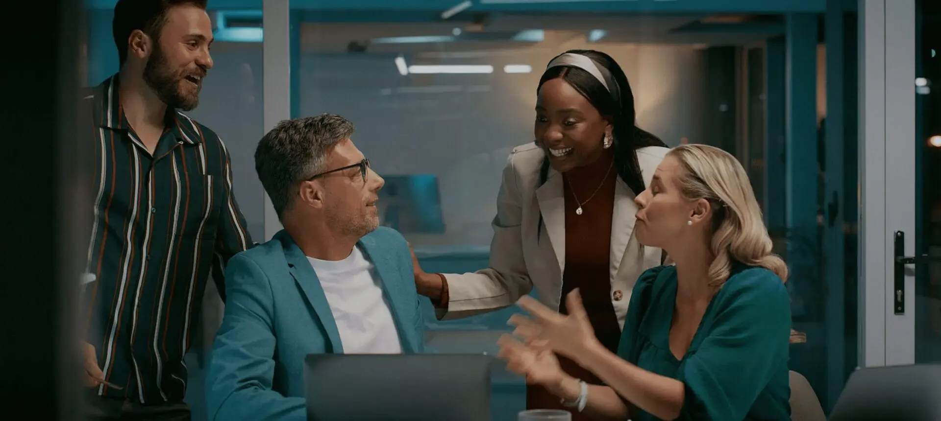 Three colleagues engaged in a lively discussion in a modern office.