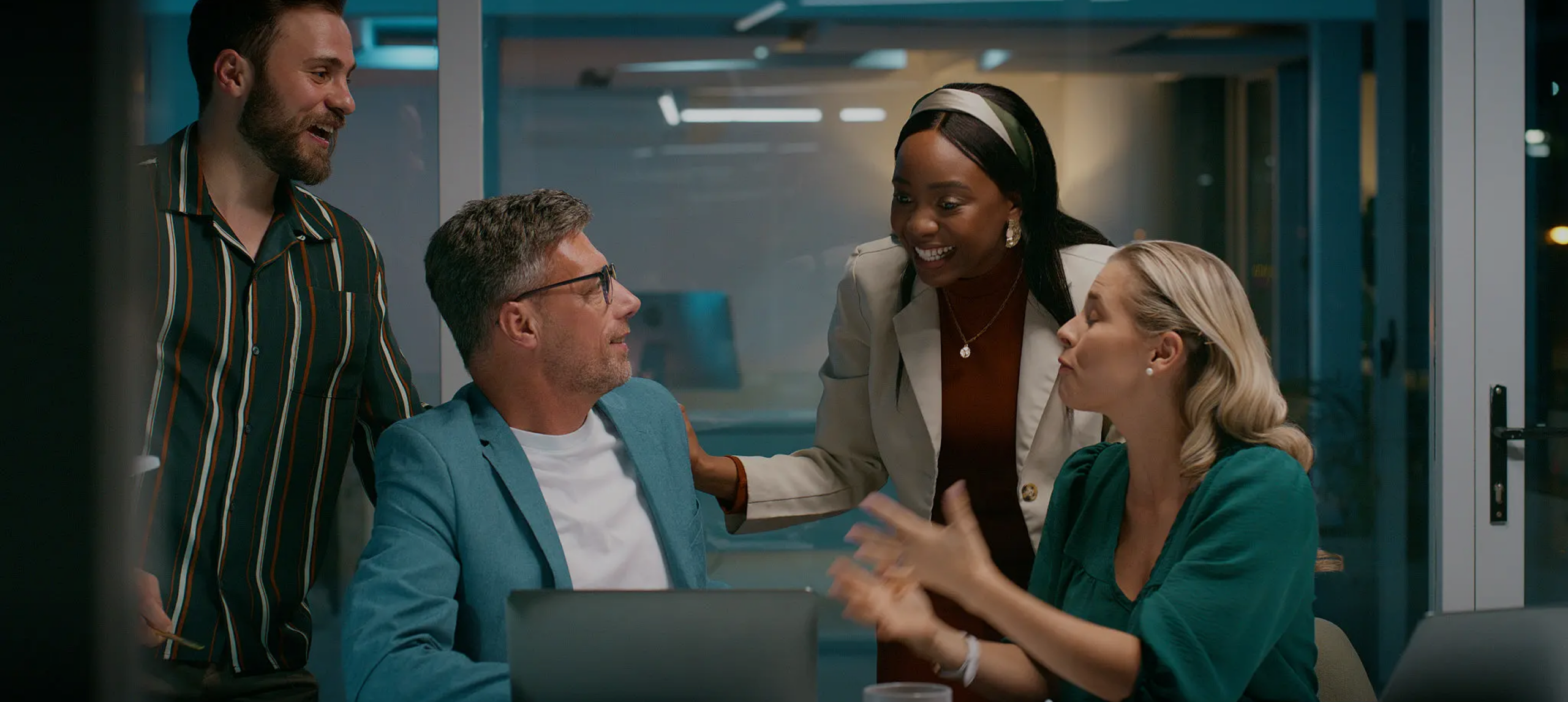 Three colleagues engaged in a lively discussion in a modern office.
